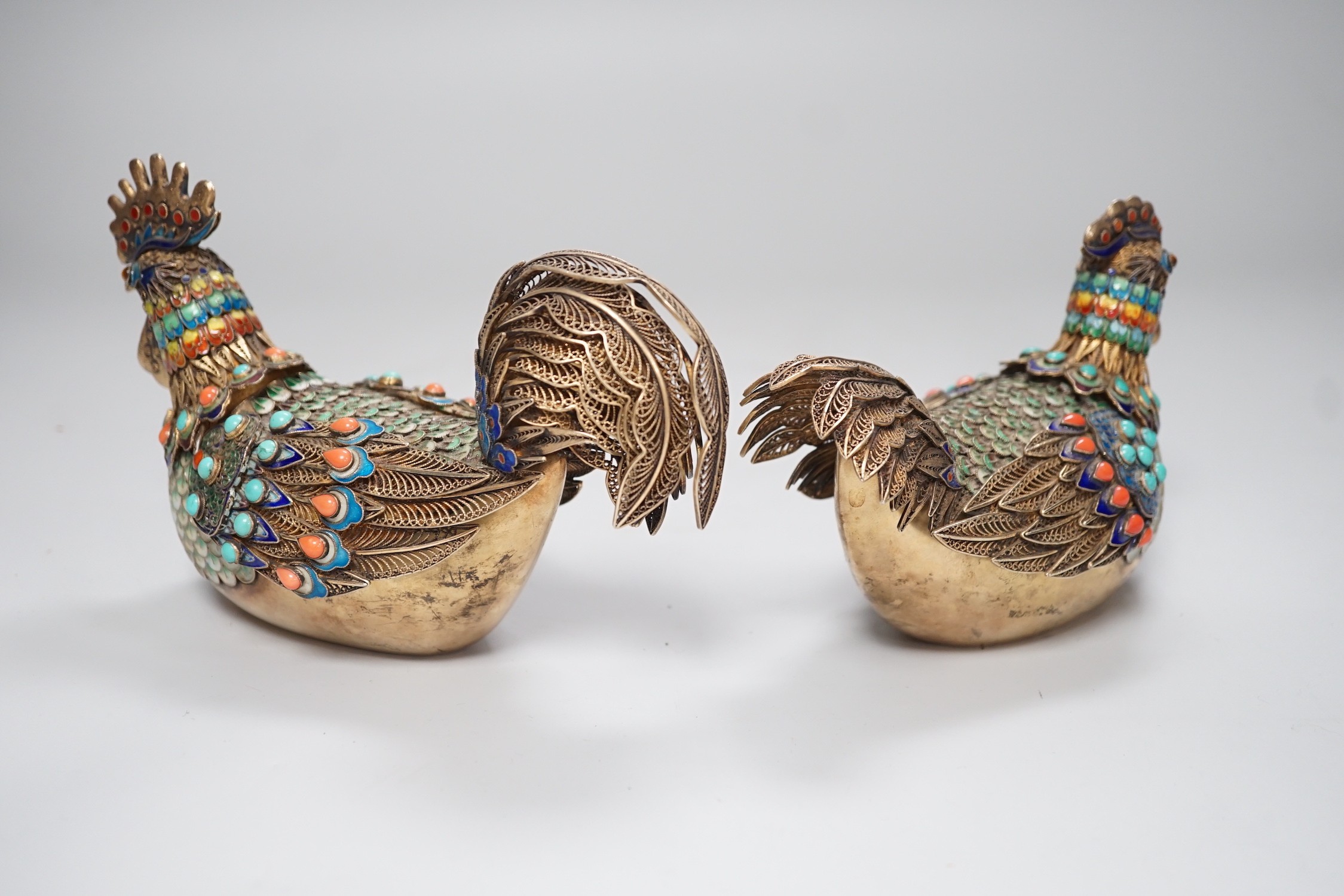 A pair of cased Chinese enamelled gilt white metal roosters with turquoise and coral mounts 14cms wide